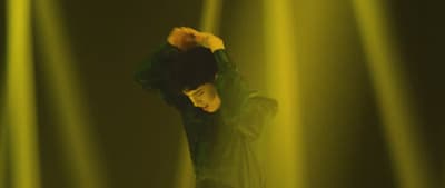 a man standing in front of a green light