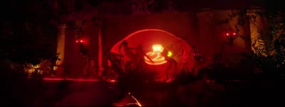 a red light in a dark room with plants