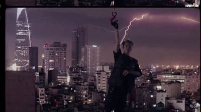 a man standing on top of a building holding a lightning bolt