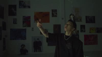 a man standing in front of a wall with pictures on it
