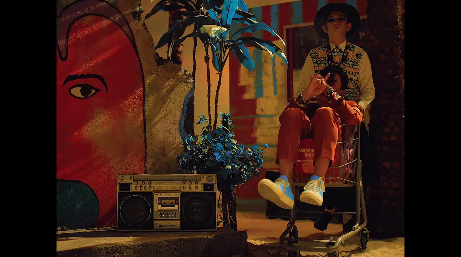 a man sitting on top of a chair next to a boombox