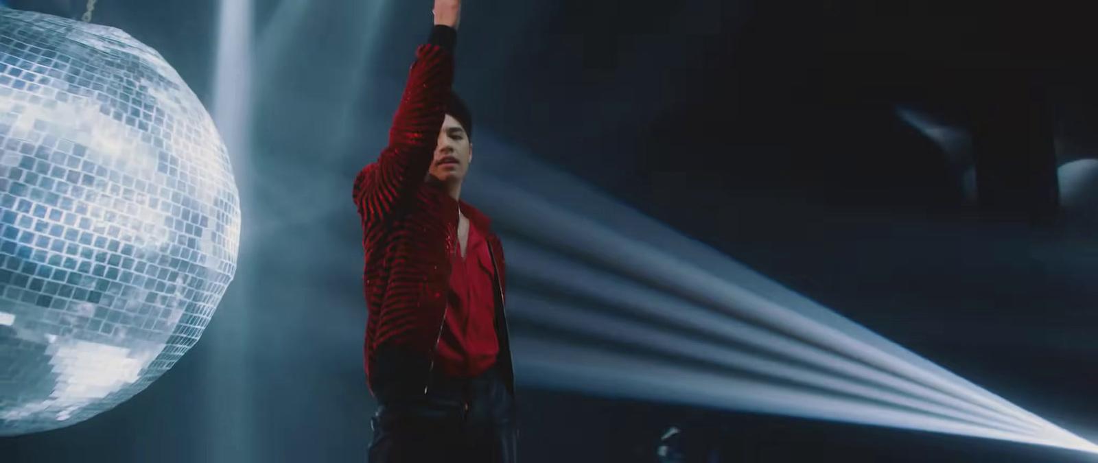 a man standing in front of a disco ball
