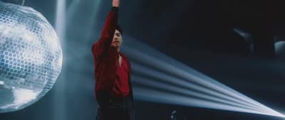 a man standing in front of a disco ball