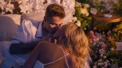 a man and a woman kissing in front of flowers