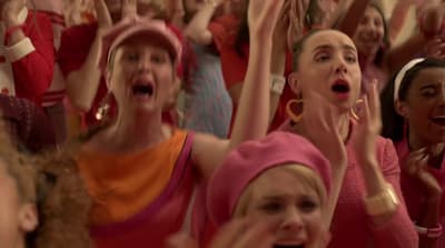 a group of women singing into microphones in front of a crowd