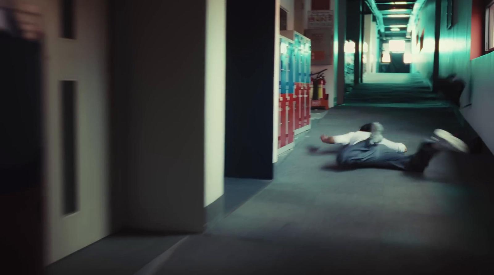 a man laying on the ground in a hallway