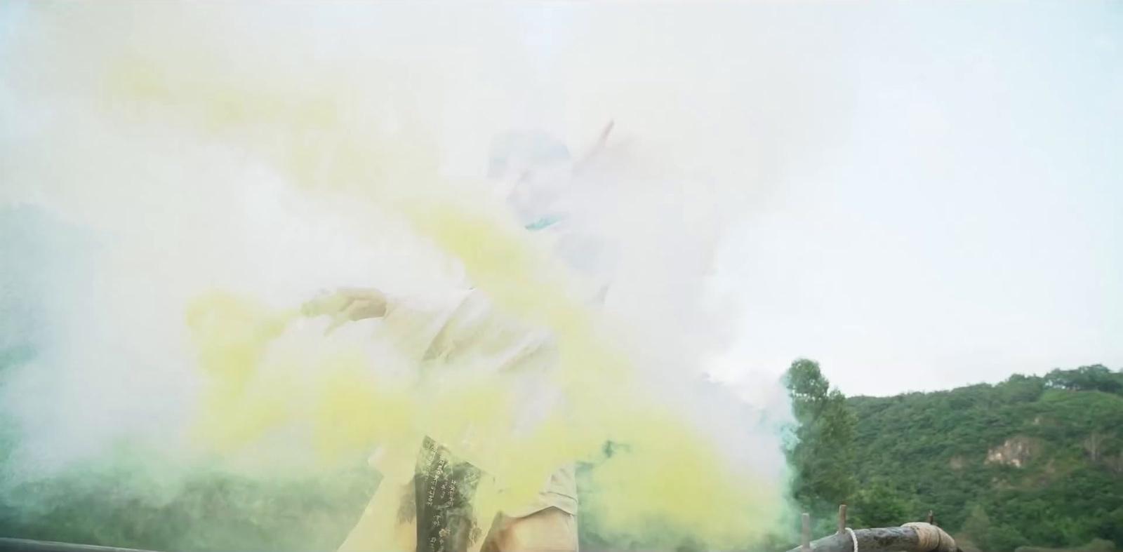 a person holding a fire hydrant in front of a cloud of smoke