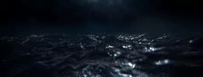 a black and white photo of the ocean at night