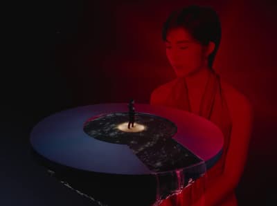 a woman standing in front of a table with a candle on it