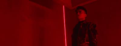 a man standing in front of a red light