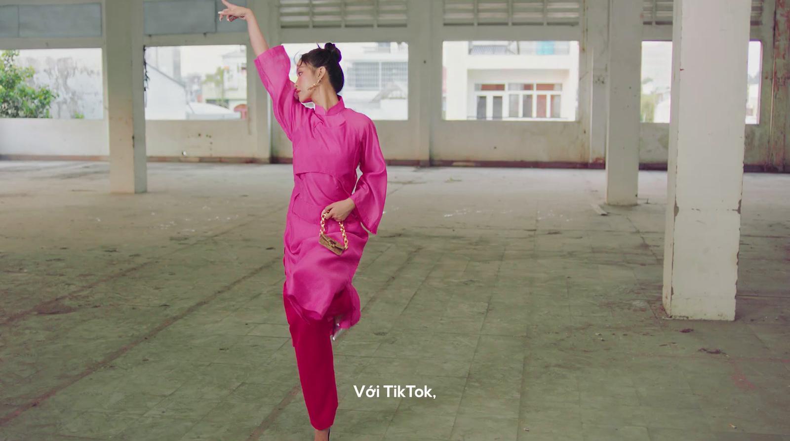 a woman in a pink outfit is dancing