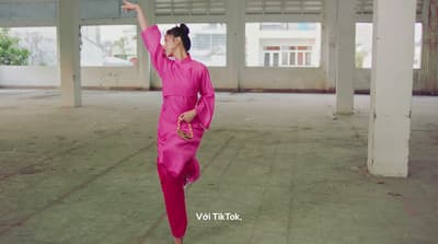 a woman in a pink outfit is dancing
