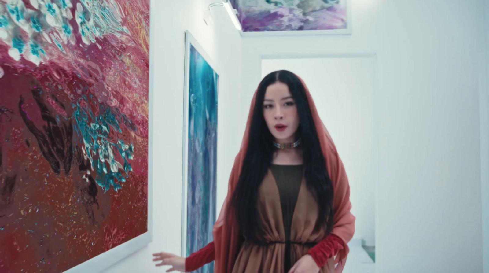 a woman standing in a hallway next to a painting