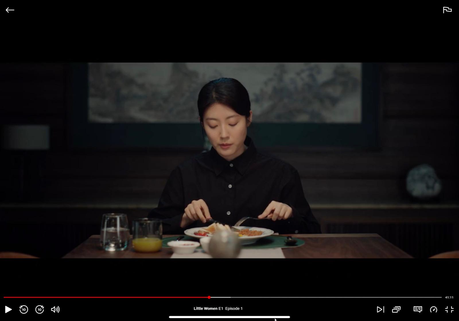 a woman sitting at a table with a plate of food