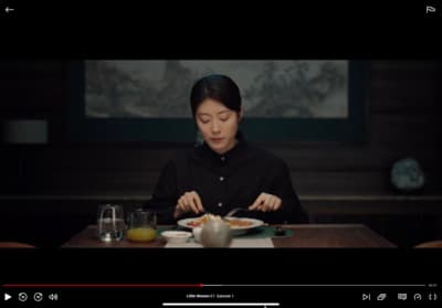a woman sitting at a table with a plate of food