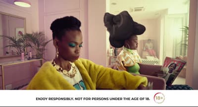 a woman sitting in front of a mirror wearing a hat