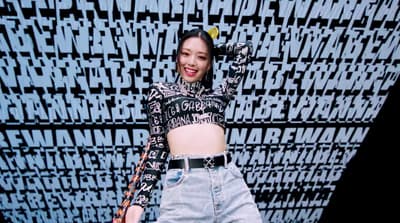 a woman in a crop top and jeans posing for a picture