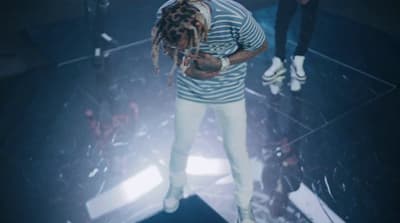 a man with dreadlocks standing on a stage