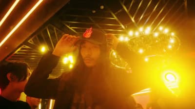 a man with long hair wearing a hat
