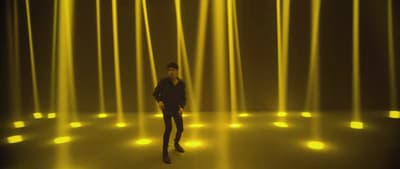 a man standing in front of a yellow light