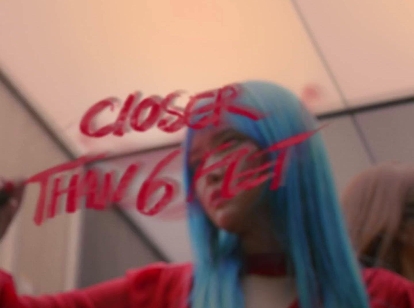 a woman with blue hair is holding a sign