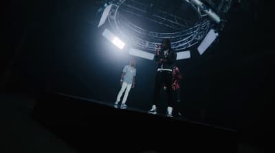 two people standing on a stage in the dark
