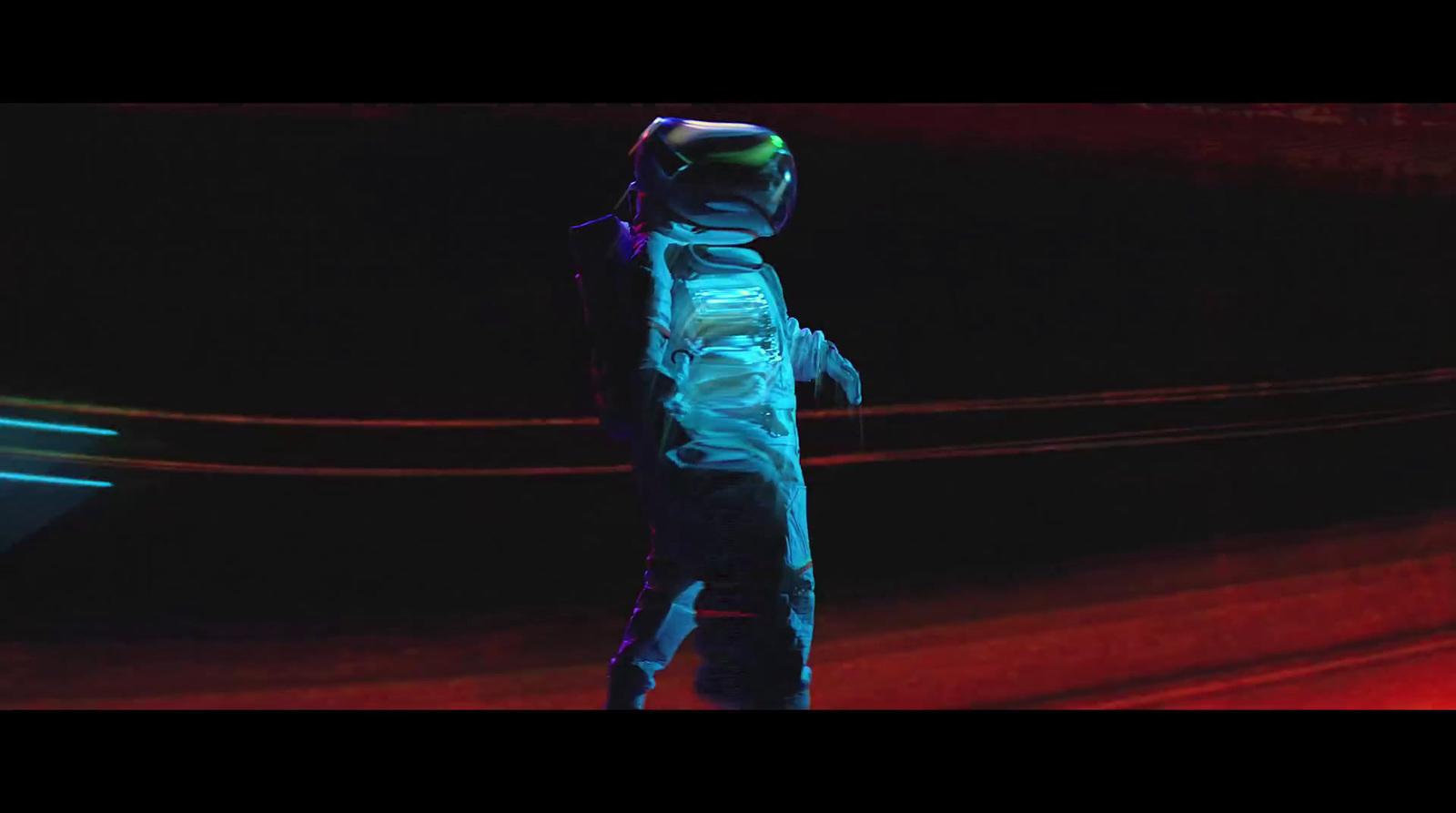 a man in a space suit standing in the dark