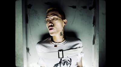 a man with glasses and a cross on his shirt