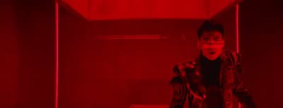 a person standing in a room with red lights