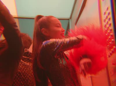 a woman with long hair wearing a red feathered dress