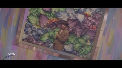 a man standing in front of a painting of butterflies