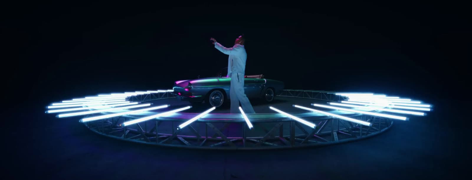 a man standing on top of a car in the dark