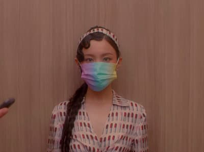 a woman wearing a face mask while holding a cell phone