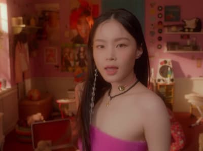 a woman in a pink dress standing in a room