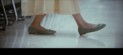 a close up of a person's shoes on a tiled floor