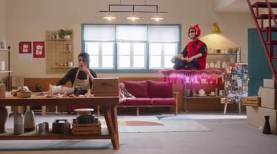 a man and a woman sitting on a couch in a living room