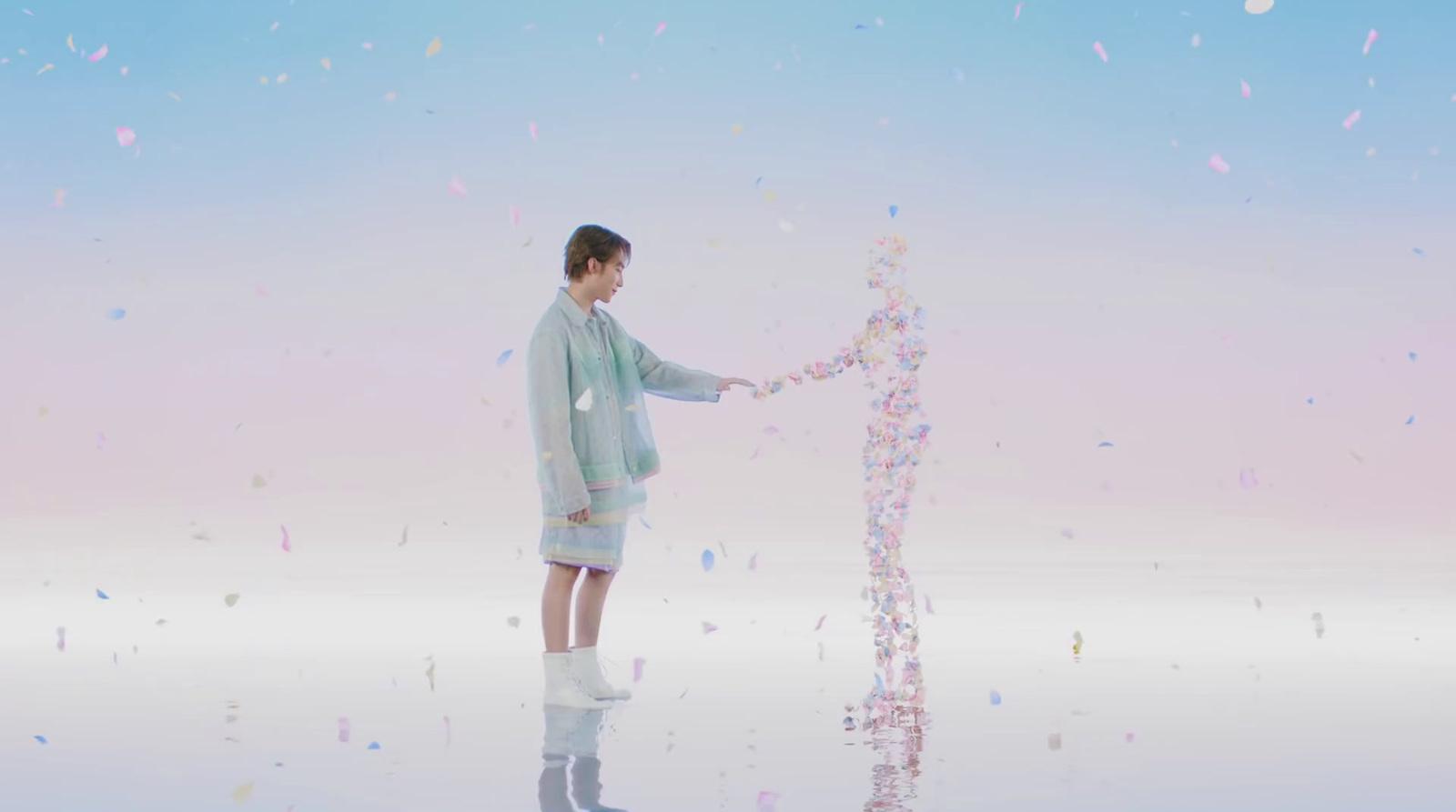 a woman standing next to a tall pink object