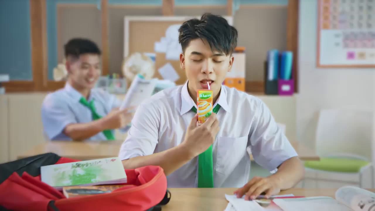 a man sitting at a desk with a toothbrush in his mouth