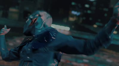 a man in a blue suit is holding his arms up in the air