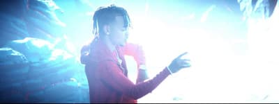 a man with dreadlocks standing in front of a microphone