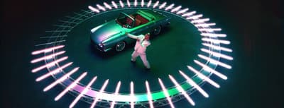 a woman standing in front of a green car