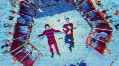 a couple of people standing on top of a snow covered slope