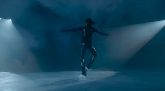 a woman in a black outfit is dancing on a stage