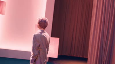a man standing in front of a curtain in a room