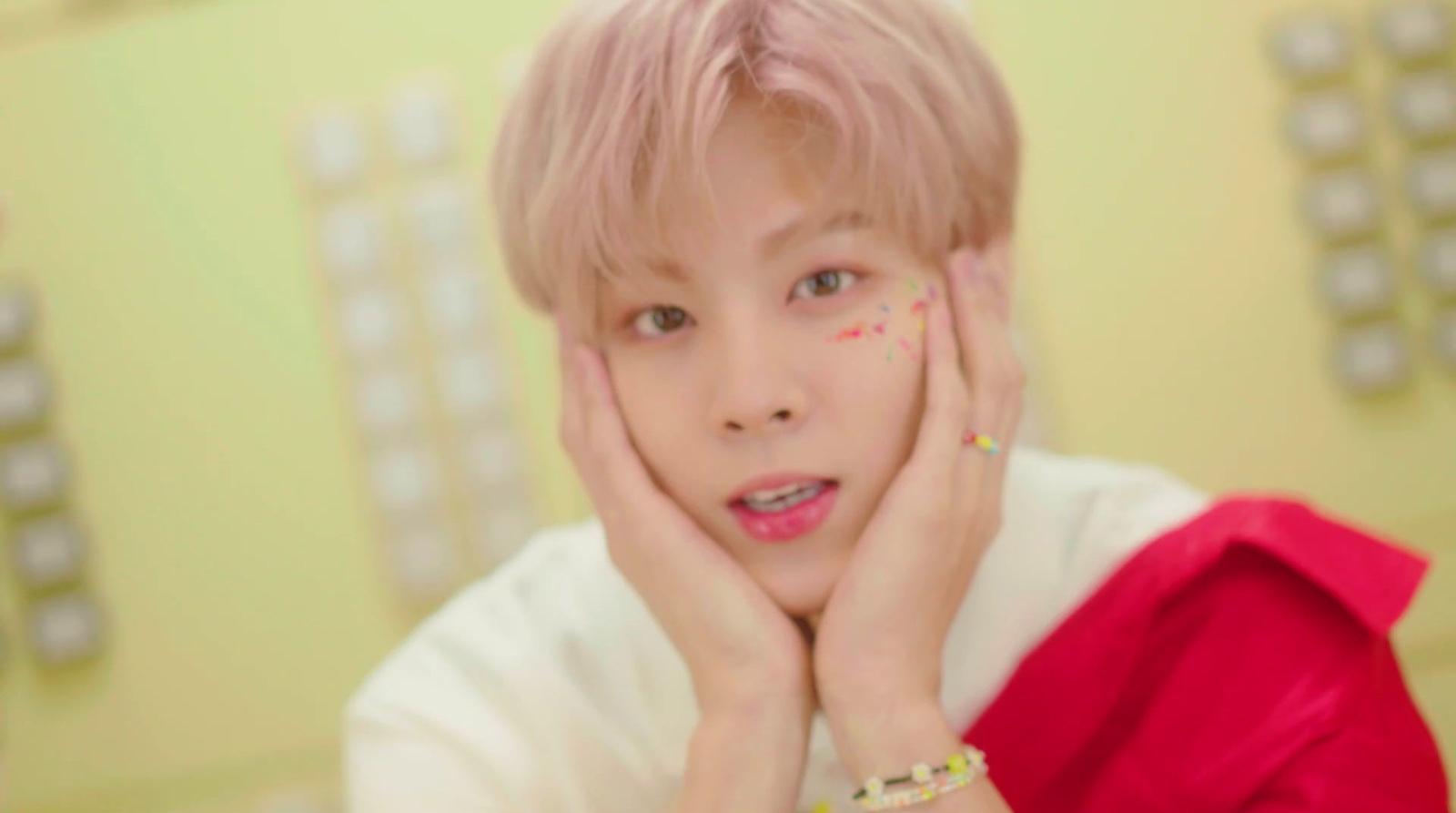 a person with pink hair and a white shirt
