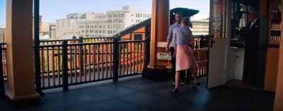 a woman standing on a balcony with an umbrella