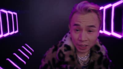 a man in a fur coat is making a face