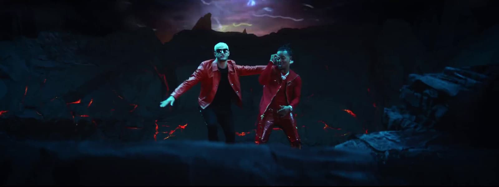 a couple of men standing next to each other in a cave