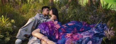 a man and a woman laying in the grass