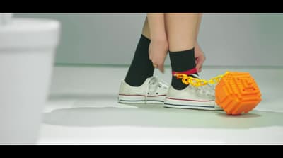 a person tying a shoelace to a pair of tennis shoes